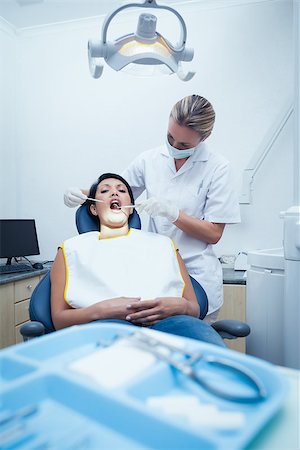 simsearch:400-07938964,k - Female dentist examining womans teeth in the dentists chair Stockbilder - Microstock & Abonnement, Bildnummer: 400-07939282