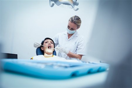 simsearch:6109-08389794,k - Female dentist examining womans teeth in the dentists chair Stockbilder - Microstock & Abonnement, Bildnummer: 400-07939283