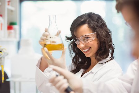 school biology - Pretty science student smiling and holding beaker at the university Stock Photo - Budget Royalty-Free & Subscription, Code: 400-07939516