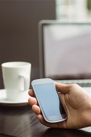 simsearch:400-08056574,k - Student holding his mobile phone in cafe at the university Stock Photo - Budget Royalty-Free & Subscription, Code: 400-07939550