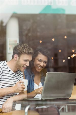 Smiling friends with a hot drink using laptop in cafe at the university Stock Photo - Budget Royalty-Free & Subscription, Code: 400-07939572