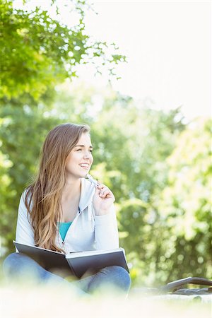 simsearch:400-07939821,k - Thinking student sitting and holding book in park at school Photographie de stock - Aubaine LD & Abonnement, Code: 400-07939635