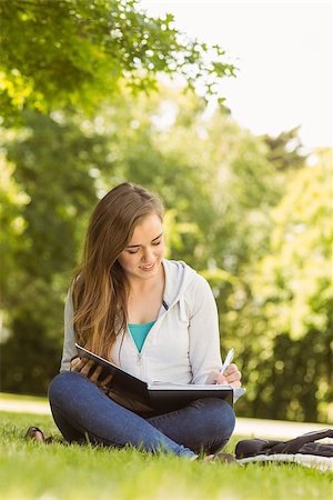 simsearch:400-07939821,k - Smiling university student sitting and writing on notepad in park at school Photographie de stock - Aubaine LD & Abonnement, Code: 400-07939636