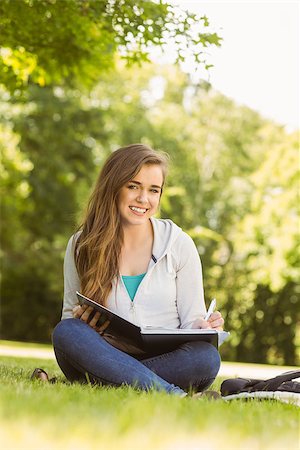 simsearch:400-07939821,k - Smiling university student sitting and writing on notepad in park at school Photographie de stock - Aubaine LD & Abonnement, Code: 400-07939637