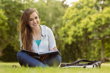 simsearch:400-07939821,k - Smiling student sitting and holding book in park at school Photographie de stock - Aubaine LD & Abonnement, Code: 400-07939633