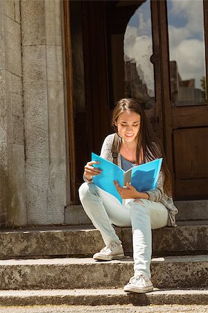 simsearch:400-07939821,k - Smiling student sitting and reading book on steps at school Photographie de stock - Aubaine LD & Abonnement, Code: 400-07939655