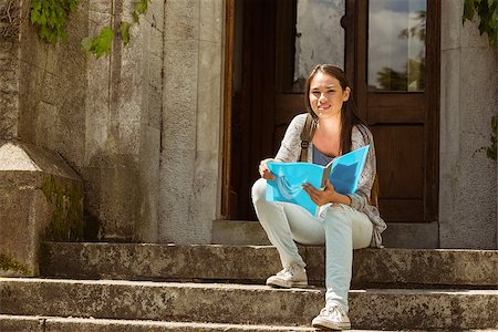 simsearch:400-07939821,k - Smiling student sitting and holding book on steps at school Photographie de stock - Aubaine LD & Abonnement, Code: 400-07939656