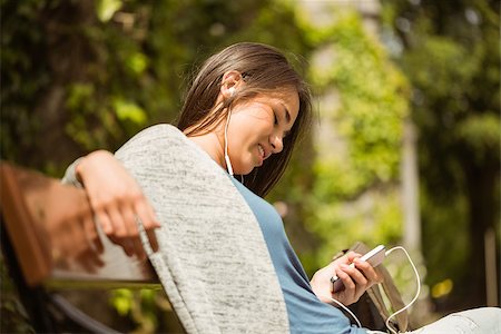 simsearch:400-08056574,k - Smiling student sitting on bench text message on her mobile phone in park at school Stock Photo - Budget Royalty-Free & Subscription, Code: 400-07939665