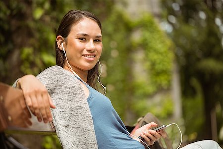 students campus phones - Smiling student sitting on bench listening music with mobile phone in park at school Stock Photo - Budget Royalty-Free & Subscription, Code: 400-07939666