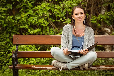 students campus phones - Smiling student sitting on bench listening music with mobile phone and holding book in park at school Stock Photo - Budget Royalty-Free & Subscription, Code: 400-07939668