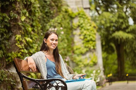 students campus phones - Smiling student sitting on bench holding her mobile phone in park at school Stock Photo - Budget Royalty-Free & Subscription, Code: 400-07939661