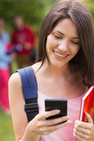 students campus phones - Pretty student sending a text outside on campus at the university Stock Photo - Budget Royalty-Free & Subscription, Code: 400-07939815