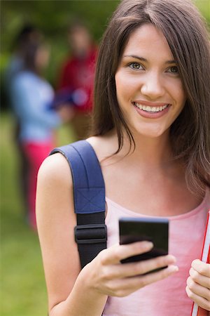 simsearch:400-06204445,k - Pretty student sending a text outside on campus at the university Foto de stock - Royalty-Free Super Valor e Assinatura, Número: 400-07939816