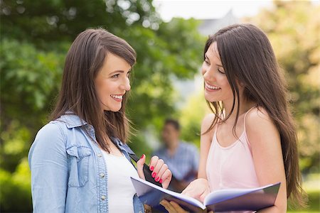 simsearch:400-07939821,k - Pretty students reading from notepad at the university Photographie de stock - Aubaine LD & Abonnement, Code: 400-07939820