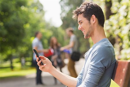 students campus phones - Handsome student sending a text outside at the university Stock Photo - Budget Royalty-Free & Subscription, Code: 400-07939839