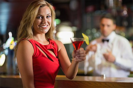 simsearch:693-06021224,k - Pretty blonde smiling at camera with cocktail in a bar Stock Photo - Budget Royalty-Free & Subscription, Code: 400-07939890