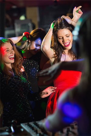 simsearch:400-07939979,k - Happy friends dancing by the dj booth at the nightclub Fotografie stock - Microstock e Abbonamento, Codice: 400-07939975