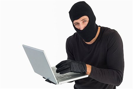 simsearch:400-06803569,k - Burglar standing holding laptop while looking at camera on white background Stock Photo - Budget Royalty-Free & Subscription, Code: 400-07930086