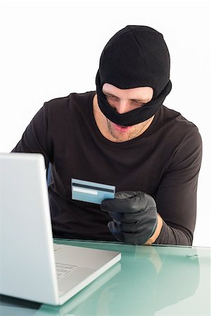 simsearch:400-06803569,k - Burglar shopping online with laptop on white background Stock Photo - Budget Royalty-Free & Subscription, Code: 400-07930083