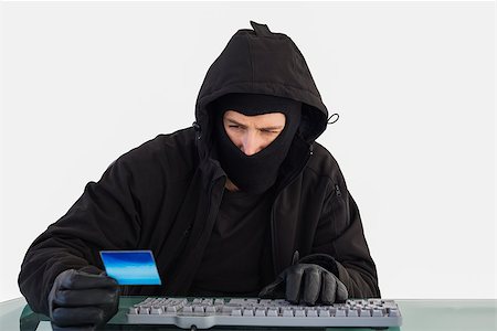 simsearch:400-06803569,k - Burglar shopping online with laptop on white background Stock Photo - Budget Royalty-Free & Subscription, Code: 400-07930090