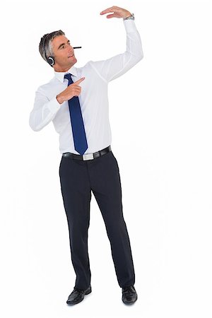 Smiling businessman with headphone pointing on white background Stock Photo - Budget Royalty-Free & Subscription, Code: 400-07930441