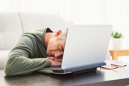 Man sleeping on his laptop at home in the living room Photographie de stock - Aubaine LD & Abonnement, Code: 400-07930636