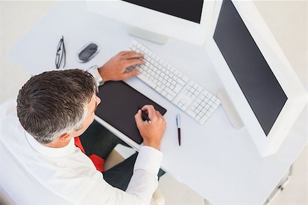 simsearch:400-06879262,k - Businessman using digital tablet and computer in his office Stock Photo - Budget Royalty-Free & Subscription, Code: 400-07930763