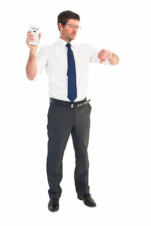 simsearch:400-07931035,k - Serious businessman holding calculator checking time on white background Stock Photo - Budget Royalty-Free & Subscription, Code: 400-07930804