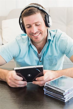 simsearch:400-07931092,k - A man listening to cds at home in the living room Foto de stock - Super Valor sin royalties y Suscripción, Código: 400-07931020