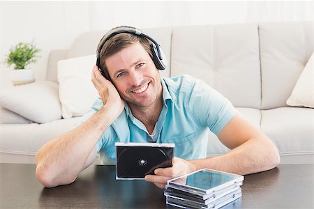 simsearch:400-07931092,k - Smiling man listening to cds at home in the living room Foto de stock - Super Valor sin royalties y Suscripción, Código: 400-07931021