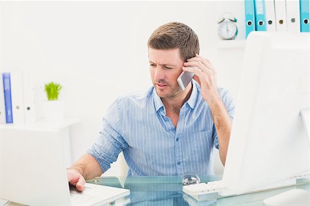 simsearch:400-07931035,k - Businessman on the phone using his laptop at desk in his office Stock Photo - Budget Royalty-Free & Subscription, Code: 400-07931047