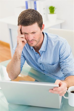 simsearch:400-07931035,k - Focused businessman looking at laptop in his office Stock Photo - Budget Royalty-Free & Subscription, Code: 400-07931054