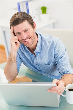 simsearch:400-07931035,k - Smiling businessman using his laptop at desk in his office Stock Photo - Budget Royalty-Free & Subscription, Code: 400-07931055