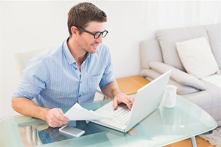 simsearch:400-07931035,k - Smiling businessman using his laptop at desk in his office Stock Photo - Budget Royalty-Free & Subscription, Code: 400-07931058