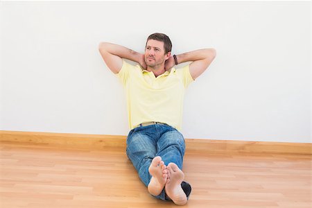 simsearch:400-07931092,k - Casual man sitting on floor at home in the living room Foto de stock - Super Valor sin royalties y Suscripción, Código: 400-07931088