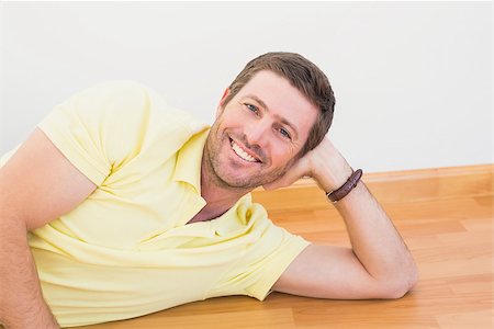 simsearch:400-07931092,k - Smiling man lying on the floor at home in the living room Foto de stock - Super Valor sin royalties y Suscripción, Código: 400-07931097