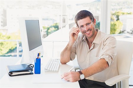 simsearch:400-07931035,k - Smiling casual businessman worknig at his desk in his office Stock Photo - Budget Royalty-Free & Subscription, Code: 400-07931104