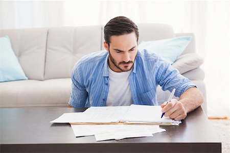 simsearch:400-07333928,k - Focused man paying his bills in the living room Stock Photo - Budget Royalty-Free & Subscription, Code: 400-07931281