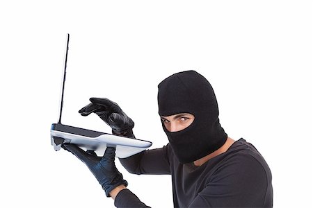 Focused burglar hacking into laptop on white background Foto de stock - Royalty-Free Super Valor e Assinatura, Número: 400-07931487