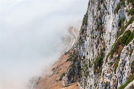 Gibraltar cliff face above fog with road below. Fotografie stock - Microstock e Abbonamento, Codice: 400-07932796