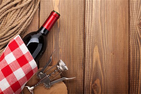 simsearch:400-07933837,k - Red wine bottle and corkscrew over rustic wooden table background with copy space Stockbilder - Microstock & Abonnement, Bildnummer: 400-07933836