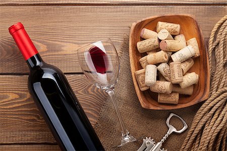 simsearch:400-07933837,k - Red wine bottle, glass of wine, bowl with corks and corkscrew. View from above over rustic wooden table background Stockbilder - Microstock & Abonnement, Bildnummer: 400-07933844