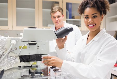 Pretty science student using microscope at the university Stock Photo - Budget Royalty-Free & Subscription, Code: 400-07940279