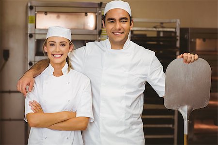 Team of bakers smiling at camera in a commercial kitchen Stock Photo - Budget Royalty-Free & Subscription, Code: 400-07940568