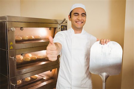 simsearch:400-07615342,k - Baker smiling at camera beside oven in a commercial kitchen Stock Photo - Budget Royalty-Free & Subscription, Code: 400-07940592