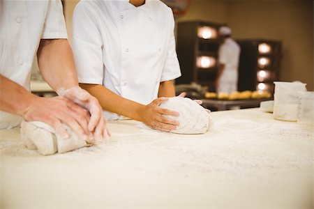 pastry chef uniform for women - Team of bakers kneading dough in a commercial kitchen Stock Photo - Budget Royalty-Free & Subscription, Code: 400-07940611