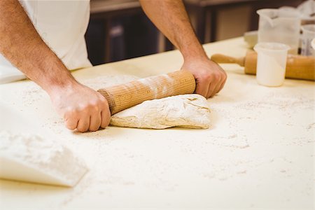 simsearch:6109-07601106,k - Baker rolling dough at a counter in a commercial kitchen Stock Photo - Budget Royalty-Free & Subscription, Code: 400-07940629