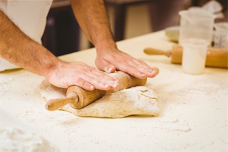 simsearch:6109-07601106,k - Baker rolling dough at a counter in a commercial kitchen Stock Photo - Budget Royalty-Free & Subscription, Code: 400-07940630