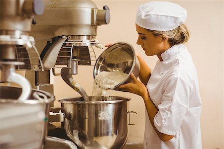 female pastry chef - Baker pouring flour into large mixer in a commercial kitchen Foto de stock - Super Valor sin royalties y Suscripción, Código: 400-07940643