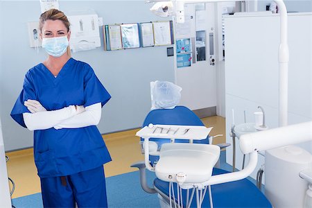 simsearch:400-07938947,k - Dentist smiling at camera with arms crossed at the dental clinic Photographie de stock - Aubaine LD & Abonnement, Code: 400-07940709